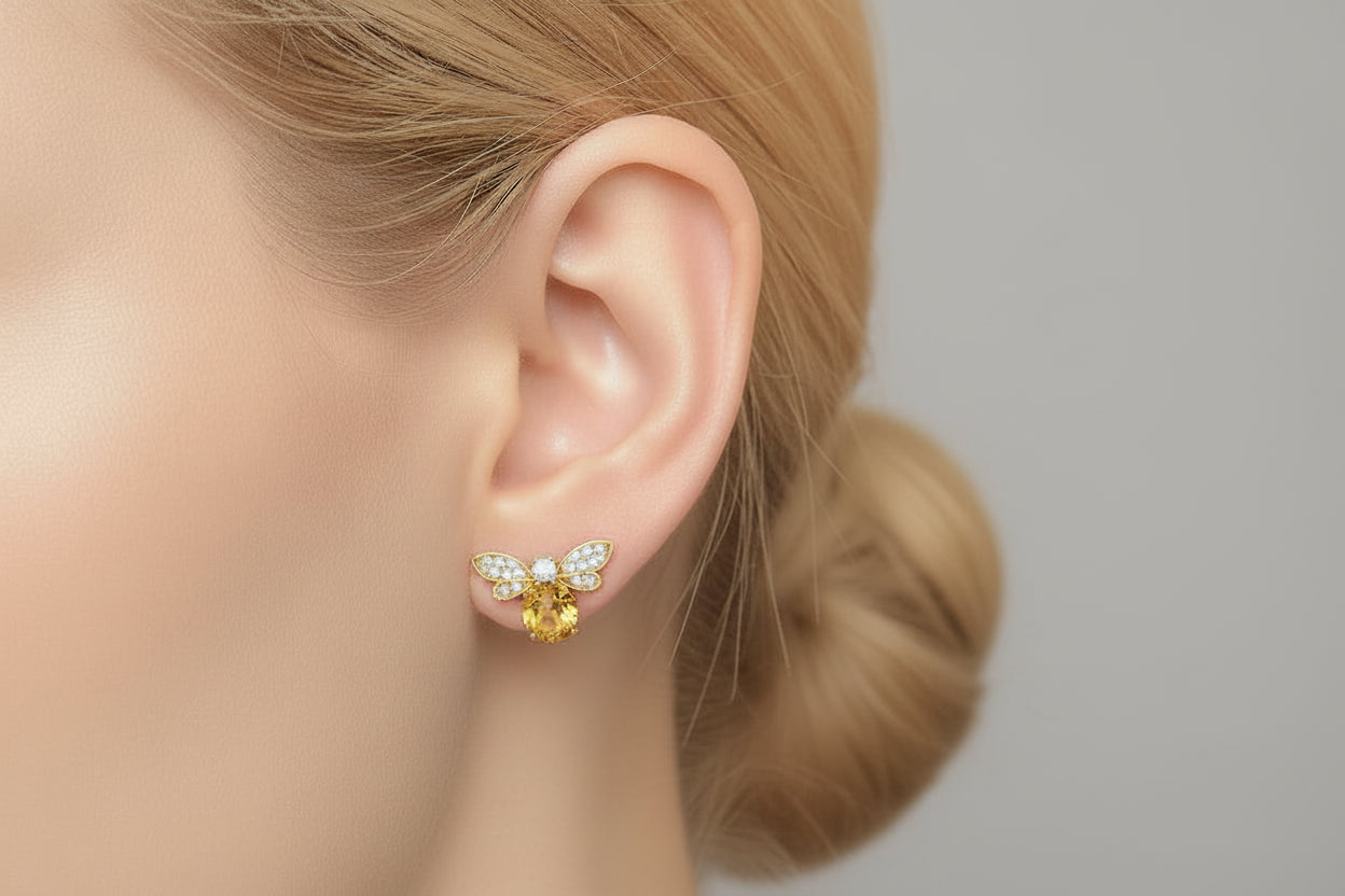 Gold butterfly earrings with a central gemstone